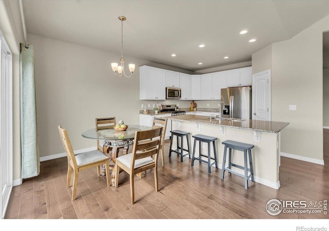 1368 Waterfall St, Timnath, CO 80547 - dining area with light wood-style floors, recessed lighting, baseboards, and a chandelier