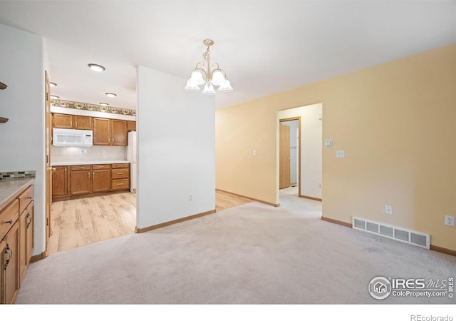 3641 Wild Horse Ct, Loveland, CO 80538 - unfurnished dining area with a chandelier, light colored carpet, and baseboards