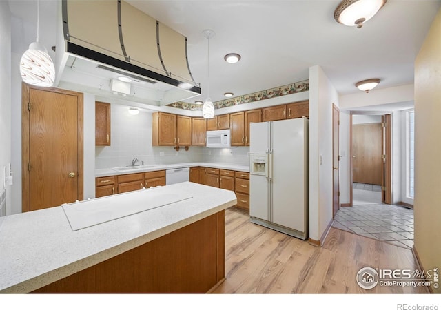 3641 Wild Horse Ct, Loveland, CO 80538 - kitchen with white appliances, a sink, brown cabinetry, light countertops, and pendant lighting