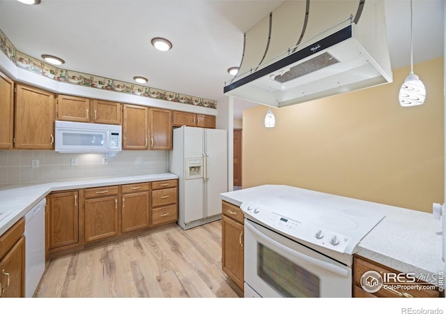 3641 Wild Horse Ct, Loveland, CO 80538 - kitchen featuring white appliances, exhaust hood, brown cabinets, decorative light fixtures, and light countertops
