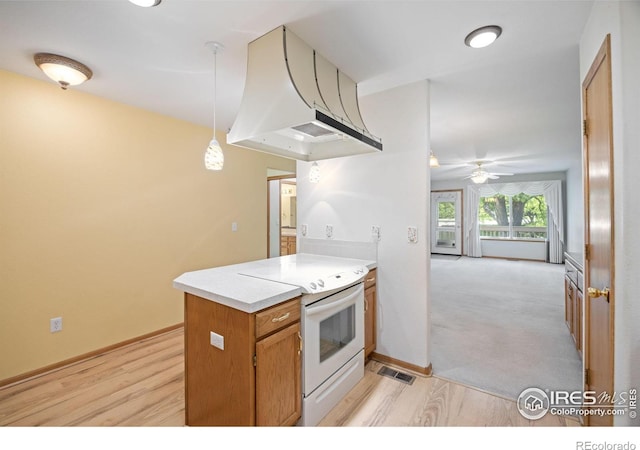3641 Wild Horse Ct, Loveland, CO 80538 - kitchen with white electric range oven, a peninsula, light wood-style floors, and a ceiling fan