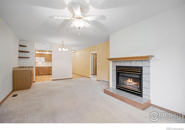3641 Wild Horse Ct, Loveland, CO 80538 - unfurnished living room with a tiled fireplace, light carpet, ceiling fan, and baseboards