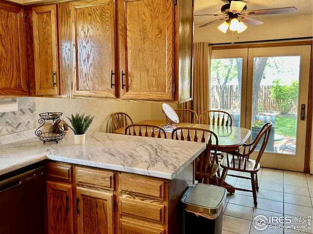 1722 Pheasant Rdg, Sterling, CO 80751 - kitchen with dishwasher, brown cabinetry, decorative backsplash, light tile patterned flooring, and ceiling fan