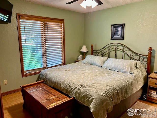 1722 Pheasant Rdg, Sterling, CO 80751 - bedroom featuring wood finished floors, a textured wall, and a ceiling fan