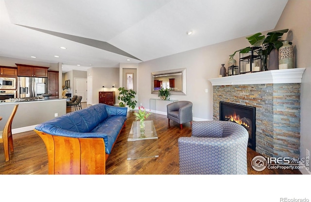 6945 N Fargo Trl, Littleton, CO 80125 - living room featuring vaulted ceiling, a stone fireplace, wood finished floors, and recessed lighting