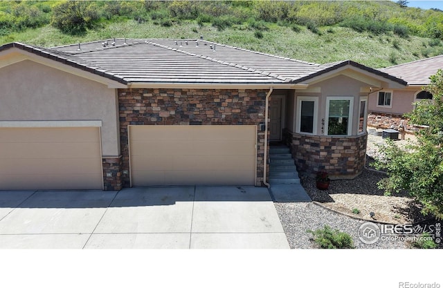 6945 N Fargo Trl, Littleton, CO 80125 - ranch-style home featuring stone siding, a garage, and stucco siding