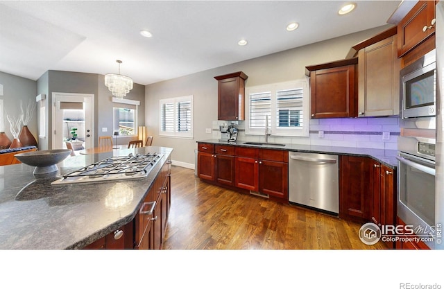 6945 N Fargo Trl, Littleton, CO 80125 - kitchen featuring stainless steel appliances, dark wood-style flooring, a chandelier, recessed lighting, and decorative backsplash