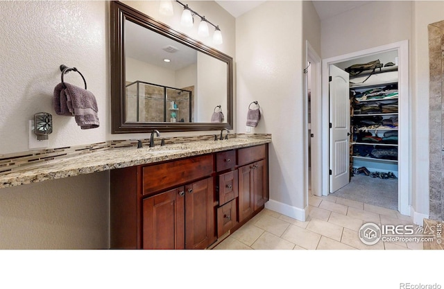 6945 N Fargo Trl, Littleton, CO 80125 - full bathroom featuring double vanity, tile patterned flooring, a shower with shower door, and a spacious closet