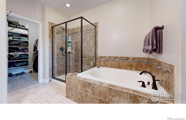 6945 N Fargo Trl, Littleton, CO 80125 - full bath with a bath, a stall shower, a walk in closet, and tile patterned flooring