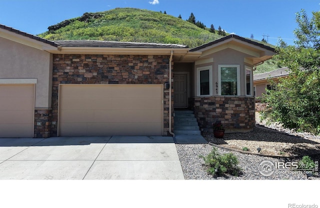 6945 N Fargo Trl, Littleton, CO 80125 - view of front of property with stone siding, an attached garage, stucco siding, and a tile roof