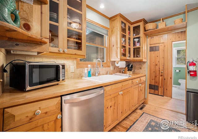 6600 State Highway 7, Estes Park, CO 80517 - kitchen with appliances with stainless steel finishes, a sink, light wood finished floors, decorative backsplash, and glass insert cabinets