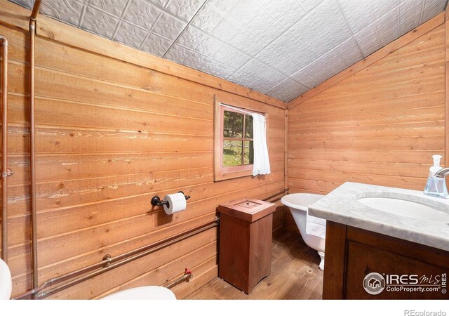 6600 State Highway 7, Estes Park, CO 80517 - bathroom with vaulted ceiling, vanity, wood finished floors, toilet, and a freestanding bath