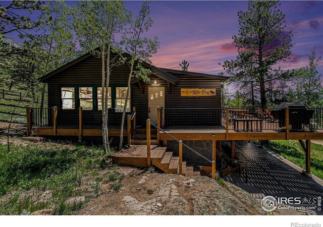 6600 State Highway 7, Estes Park, CO 80517 - back of property at dusk with a deck and log veneer siding