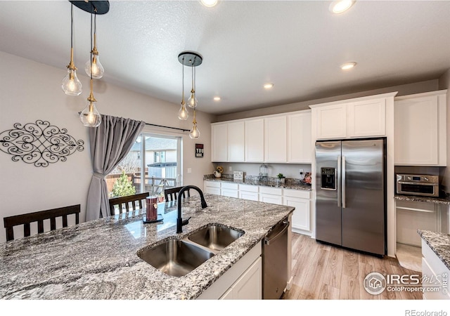 1191 Horsetail Loop, Elizabeth, CO 80107 - kitchen featuring appliances with stainless steel finishes, a sink, light wood finished floors, decorative light fixtures, and recessed lighting