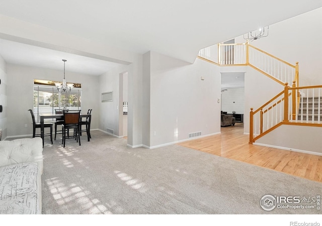 10216 Sandy Ridge Ct, Firestone, CO 80504 - carpeted living room featuring stairs, a chandelier, and baseboards