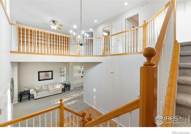 10216 Sandy Ridge Ct, Firestone, CO 80504 - staircase with carpet floors, baseboards, ceiling fan, a towering ceiling, and a chandelier
