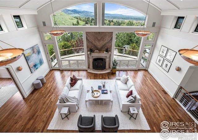 45 Bellevue Dr, Boulder, CO 80302 - living area featuring crown molding, wood finished floors, a high ceiling, a fireplace with raised hearth, and baseboards