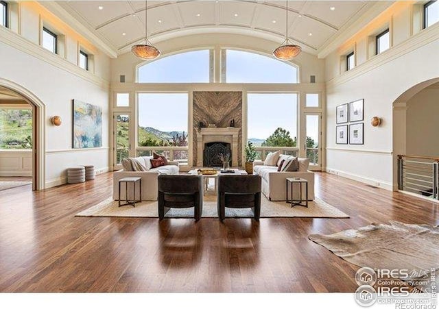45 Bellevue Dr, Boulder, CO 80302 - living area with arched walkways, high vaulted ceiling, baseboards, a fireplace, and wood finished floors