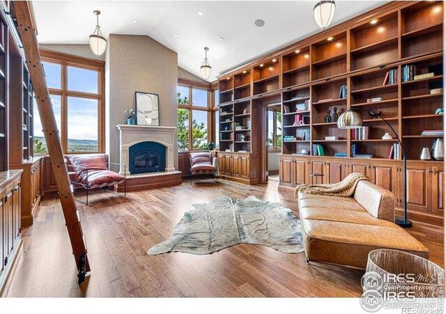 45 Bellevue Dr, Boulder, CO 80302 - living area featuring wood finished floors, vaulted ceiling, and a fireplace with raised hearth