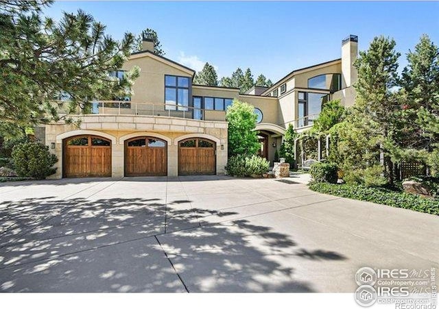 45 Bellevue Dr, Boulder, CO 80302 - view of front of house featuring a balcony, driveway, a garage, stucco siding, and a chimney