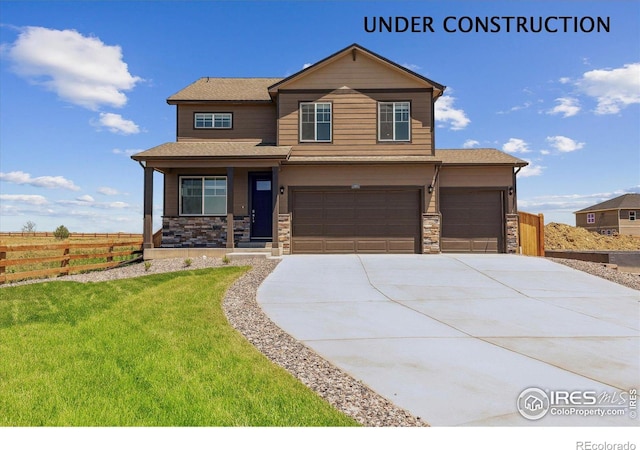 250 Chardon Ave, Brighton, CO 80601 - view of front of home with covered porch, driveway, an attached garage, and stone siding