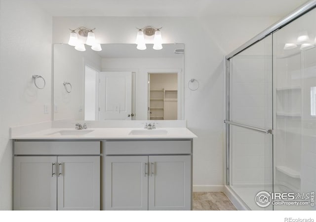 250 Chardon Ave, Brighton, CO 80601 - full bathroom featuring a shower stall, double vanity, a spacious closet, and baseboards