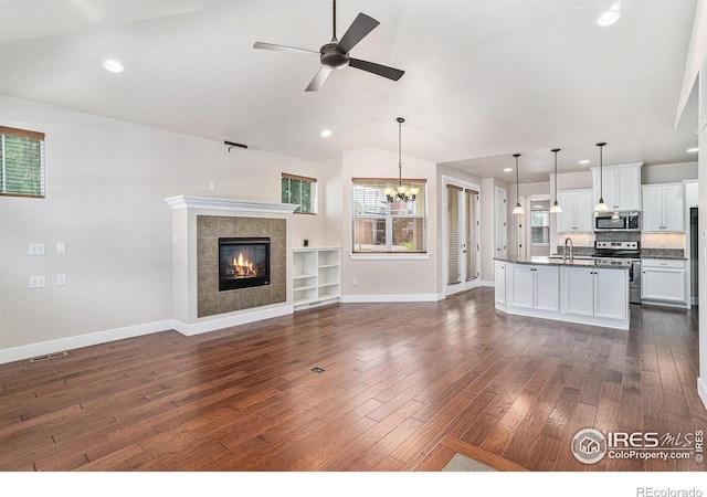 4751 Pleasant Oak Dr Unit A28, Fort Collins, CO 80525 - unfurnished living room featuring dark wood finished floors, vaulted ceiling, baseboards, plenty of natural light, and a ceiling fan