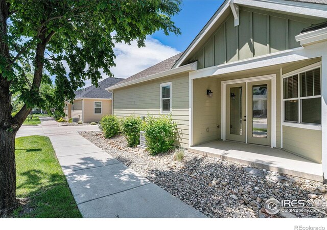 4751 Pleasant Oak Dr Unit A28, Fort Collins, CO 80525 - entrance to property with board and batten siding, a shingled roof, and french doors