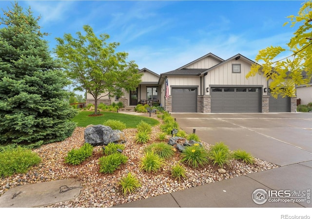 5966 Sunny Crest Dr, Timnath, CO 80547 - view of front of home featuring board and batten siding, an attached garage, stone siding, driveway, and a front lawn