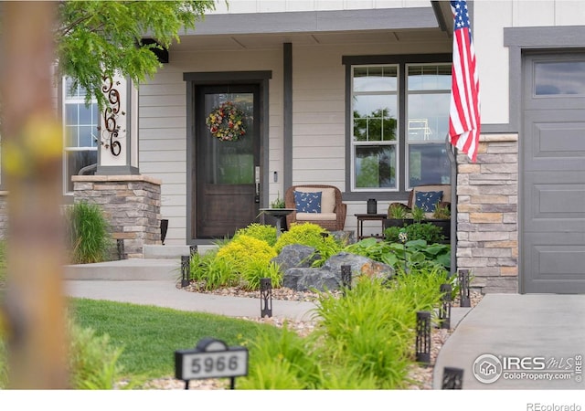 5966 Sunny Crest Dr, Timnath, CO 80547 - property entrance featuring a porch, a garage, and stone siding