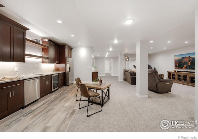 5966 Sunny Crest Dr, Timnath, CO 80547 - kitchen with beverage cooler, stainless steel appliances, dark brown cabinets, a sink, and open floor plan