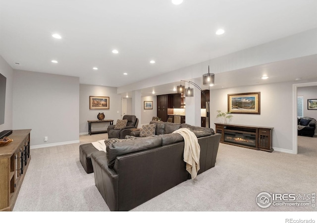 5966 Sunny Crest Dr, Timnath, CO 80547 - living room featuring light carpet, recessed lighting, baseboards, and a glass covered fireplace