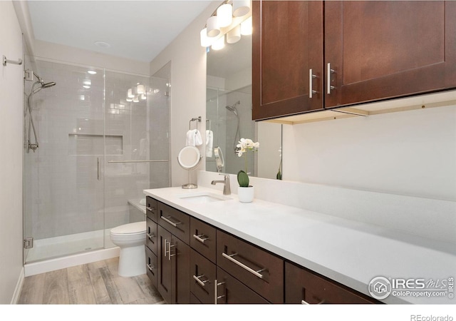 5966 Sunny Crest Dr, Timnath, CO 80547 - bathroom with a shower stall, wood finished floors, vanity, and toilet