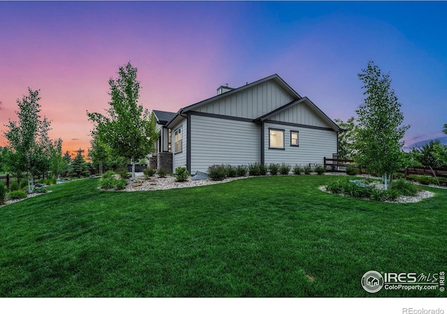 5966 Sunny Crest Dr, Timnath, CO 80547 - property exterior at dusk with a lawn, board and batten siding, and a chimney