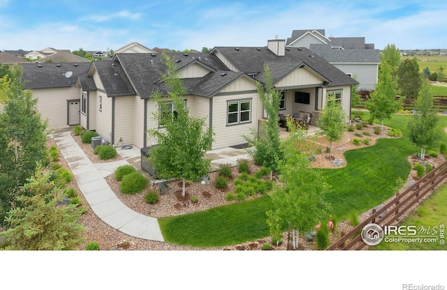 5966 Sunny Crest Dr, Timnath, CO 80547 - view of front of home featuring a patio area, board and batten siding, central AC, a shingled roof, and a front lawn