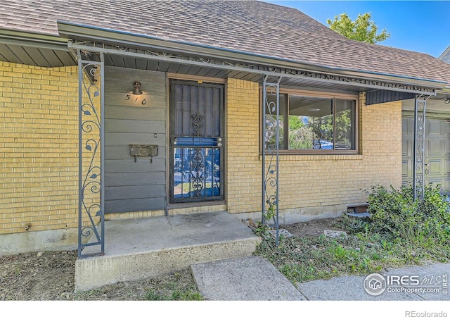510 S 46th St, Boulder, CO 80305 - doorway to property featuring a shingled roof, brick siding, and covered porch