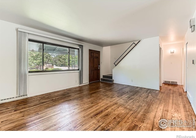 510 S 46th St, Boulder, CO 80305 - unfurnished living room featuring wood finished floors, stairs, a baseboard heating unit, and baseboards