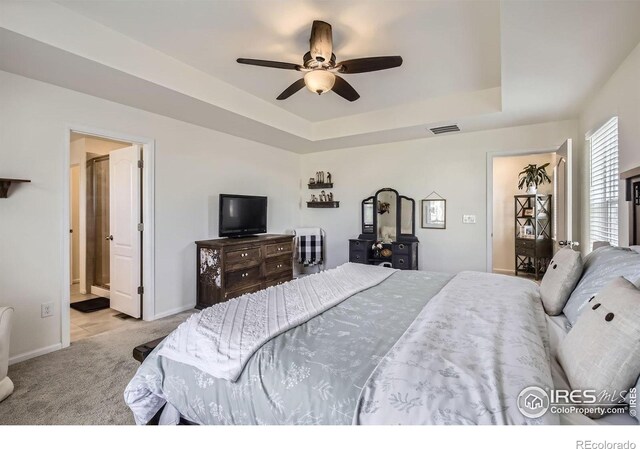 12889 Clearview St, Firestone, CO 80504 - carpeted bedroom with a tray ceiling, a ceiling fan, and ensuite bath