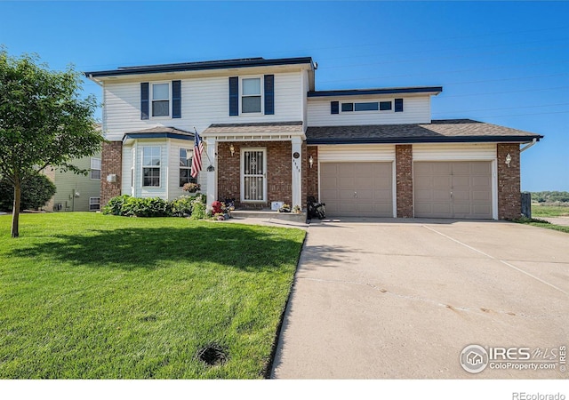 4998 32nd St, Greeley, CO 80634 - view of front of property with brick siding, concrete driveway, and a front lawn