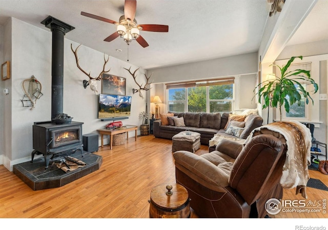 4900 W 6th Ave, Denver, CO 80204 - living room featuring wood finished floors, a wood stove, and ceiling fan
