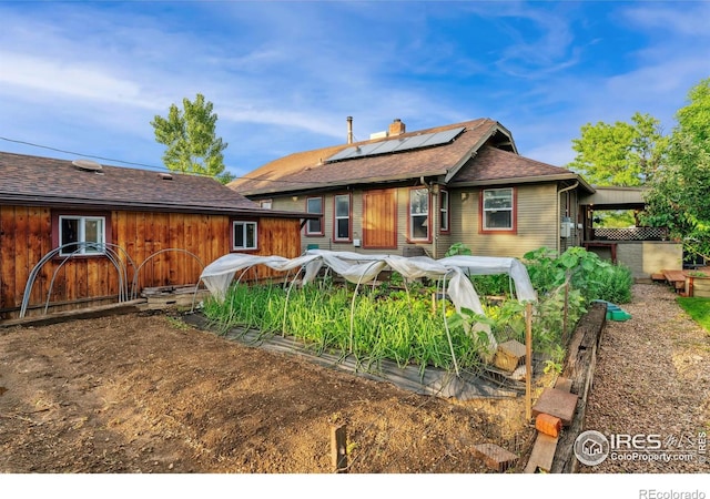 4900 W 6th Ave, Denver, CO 80204 - rear view of house featuring roof mounted solar panels, a chimney, and roof with shingles
