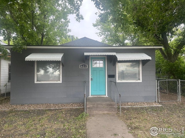 611 N 2nd St, Sterling, CO 80751 - bungalow featuring a shingled roof and a gate