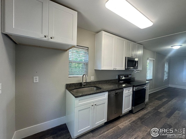611 N 2nd St, Sterling, CO 80751 - kitchen with appliances with stainless steel finishes, a sink, baseboards, and dark wood-type flooring