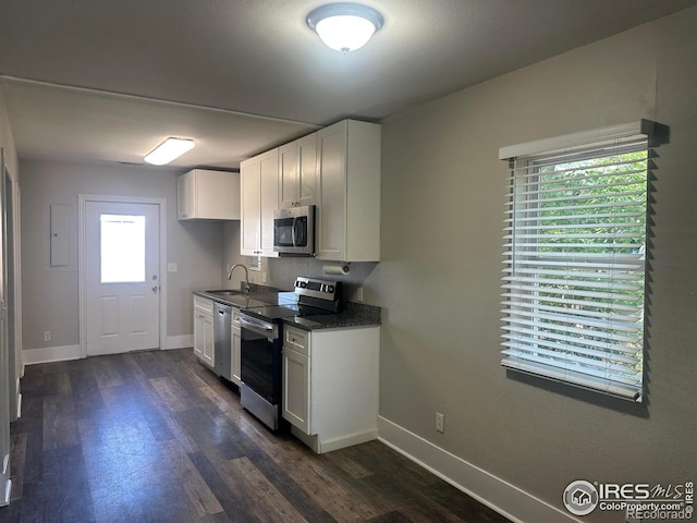 611 N 2nd St, Sterling, CO 80751 - kitchen featuring appliances with stainless steel finishes, a sink, dark wood finished floors, and baseboards