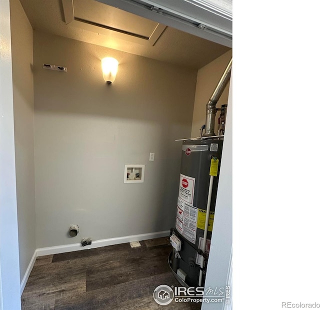 611 N 2nd St, Sterling, CO 80751 - laundry area featuring water heater, washer hookup, dark wood-style flooring, and baseboards
