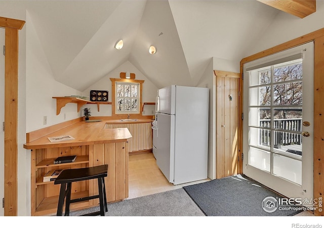 2994 75th St, Boulder, CO 80301 - kitchen with freestanding refrigerator, lofted ceiling, a peninsula, a sink, and light carpet