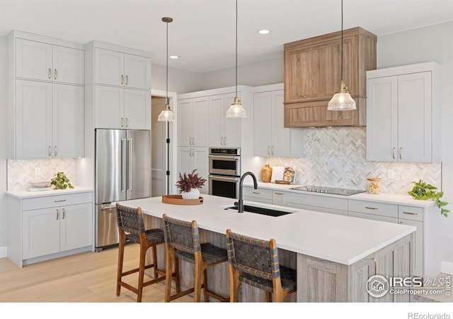 1425 Burt Ave, Berthoud, CO 80513 - kitchen with stainless steel appliances, a sink, light wood finished floors, tasteful backsplash, and light countertops