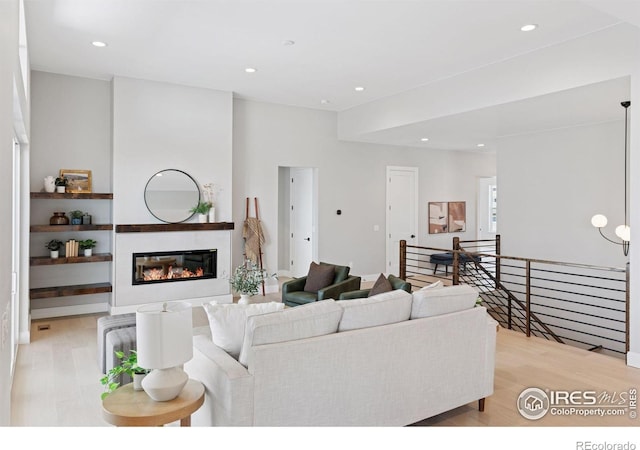 1425 Burt Ave, Berthoud, CO 80513 - living room with light wood-type flooring, a glass covered fireplace, and recessed lighting