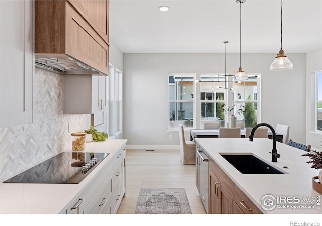 1425 Burt Ave, Berthoud, CO 80513 - kitchen featuring a sink, black electric stovetop, decorative backsplash, light countertops, and pendant lighting