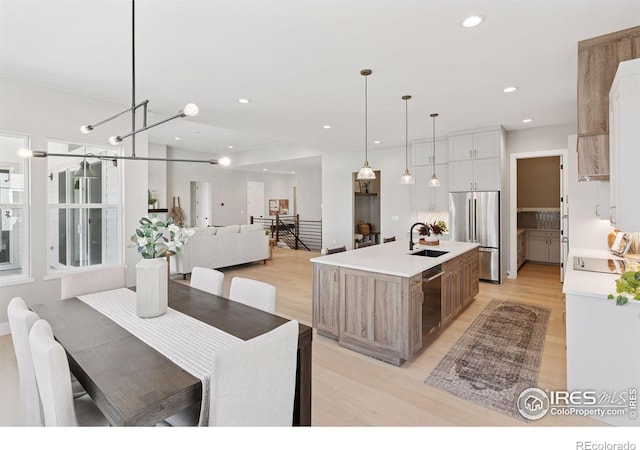 1425 Burt Ave, Berthoud, CO 80513 - kitchen with stainless steel fridge, a sink, light wood-style floors, dishwasher, and light countertops